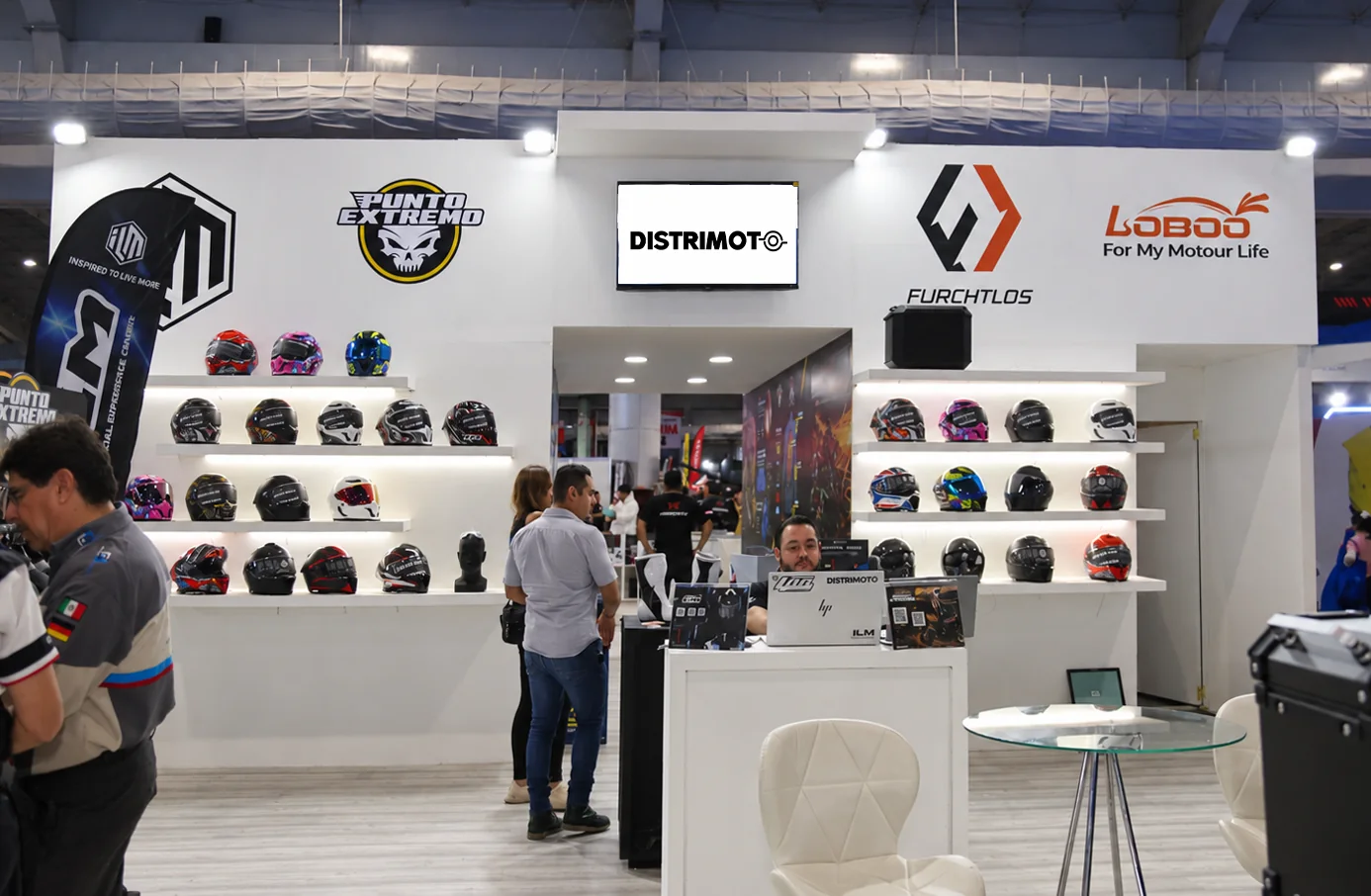 Stand de Distrimoto en una exposición, con cascos ILM y las marcas Punto Extremo, Furchtlos y LOBOO
